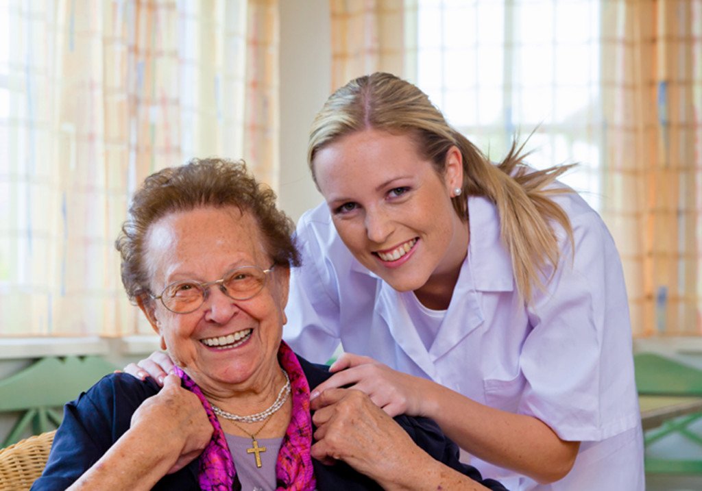 A professional carer supporting an elderly person comfortably at home